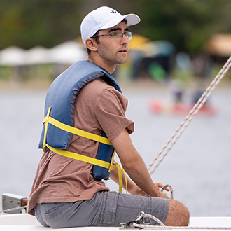 intermediate sailing at shoreline lake. A man saling in a boat on shoreline lake.