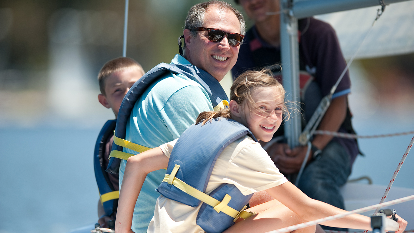 A parent sitting with their kids in a boat.